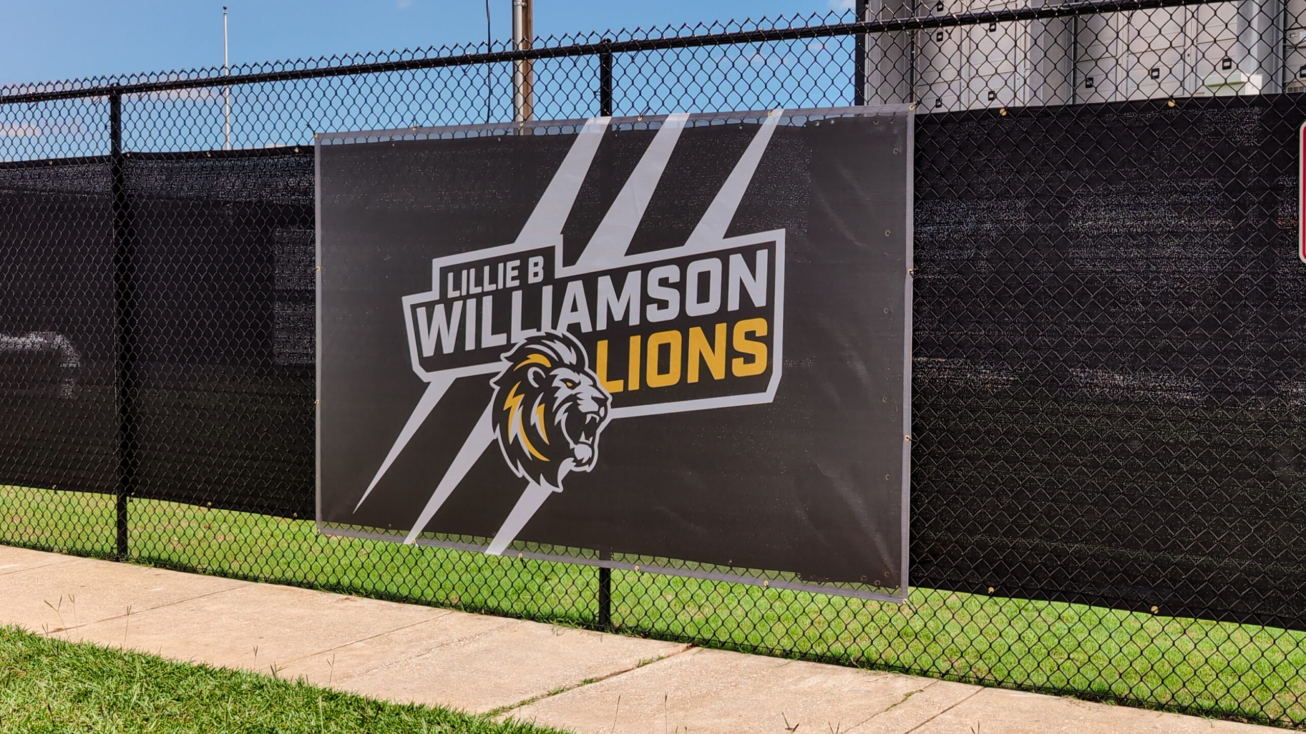 Custom banner wrap installed around the football field at Williamson High School in Mobile, Alabama, featuring bold school branding and athletic graphics.