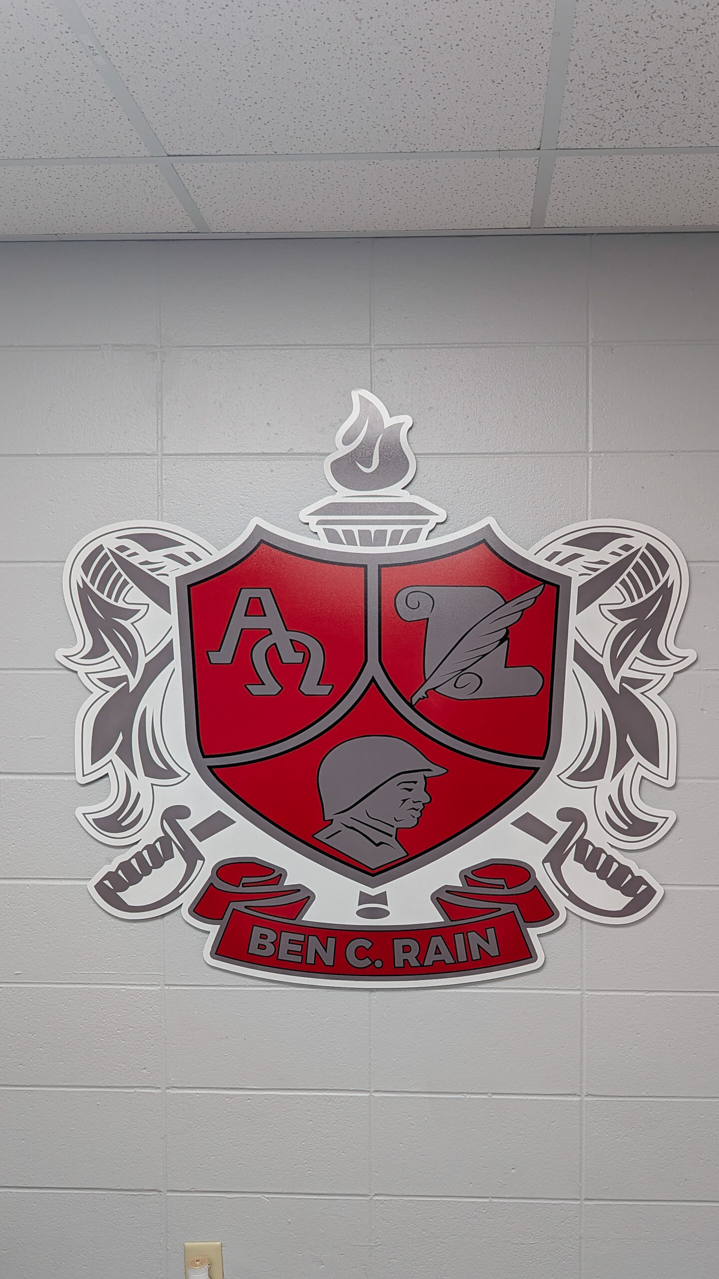 SEG wall display featuring the vision and mission statements at B.C. Rain High School in Mobile, Alabama, alongside a dimensional acrylic crest in red and gray designed and installed by Compel Printing.