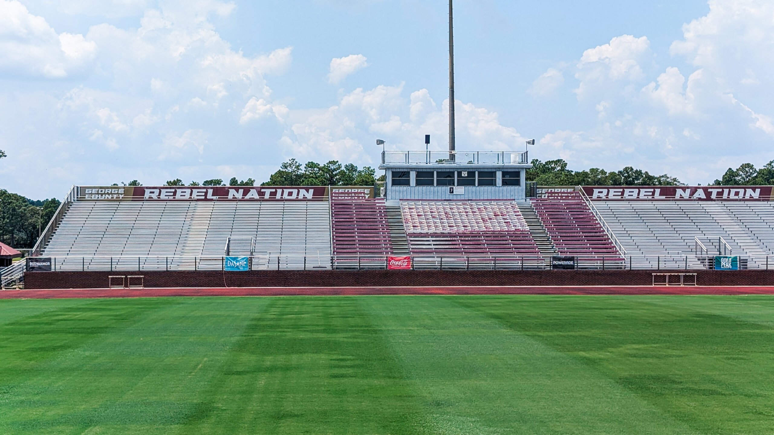 Custom maroon and white mesh banners reading “Rebel Nation” and “The Pride of George County” installed at George County High School football stadium in Lucedale, Mississippi.