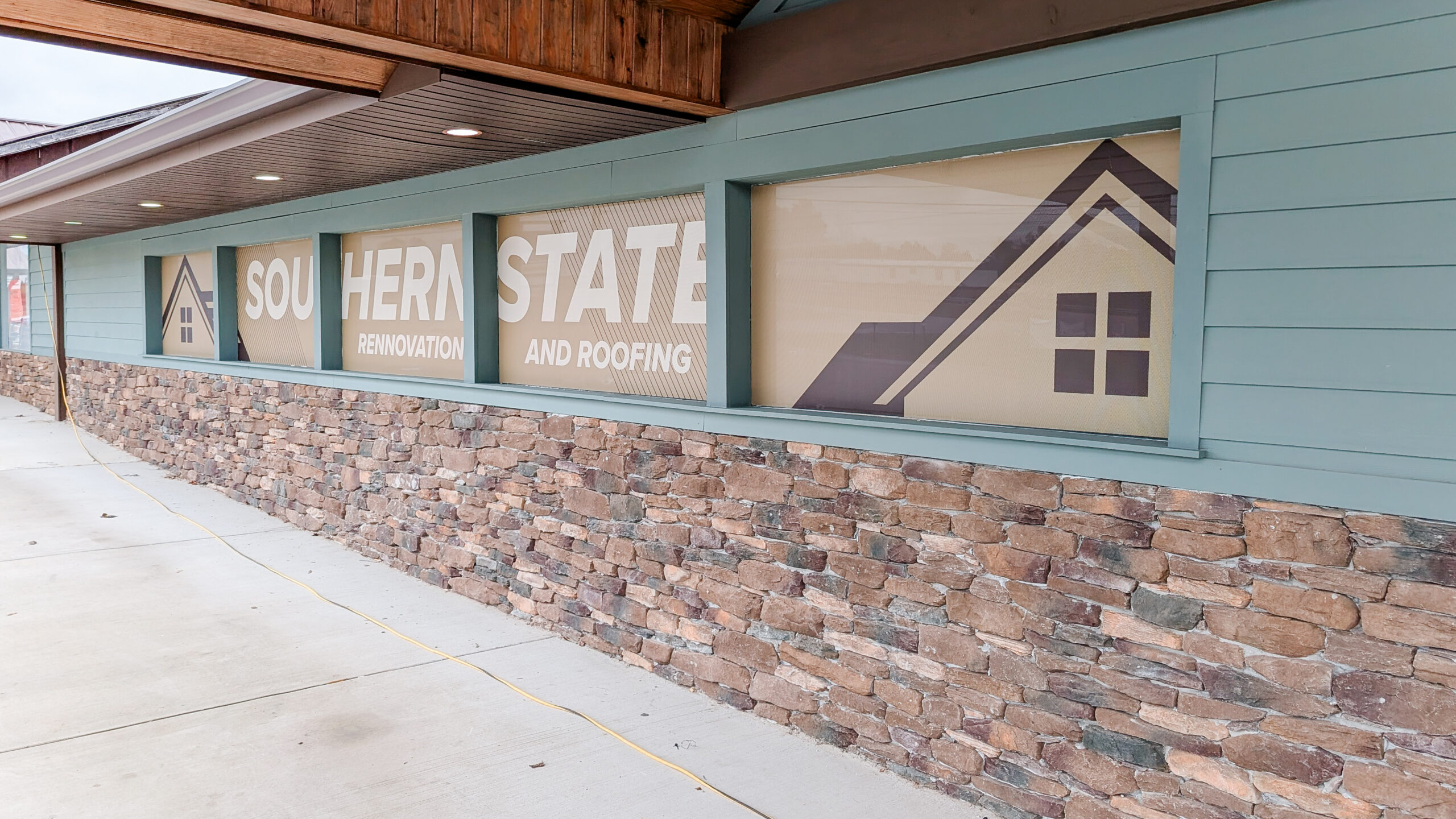 Window perf graphics installed for a small renovation and roofing company storefront.