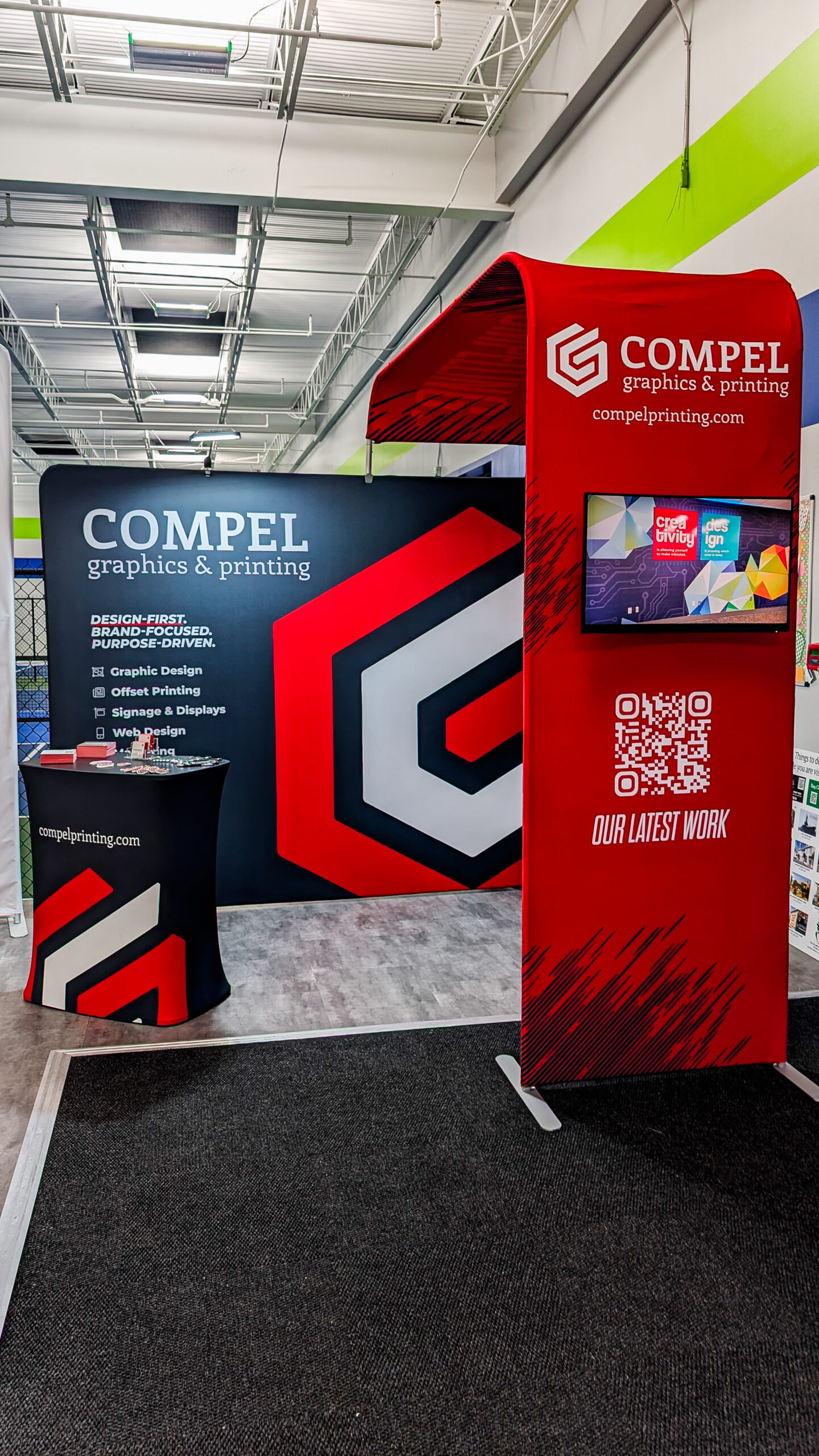 ustom trade show booth featuring fabric graphics, a branded archway, and display panels designed for Compel Graphics & Printing.