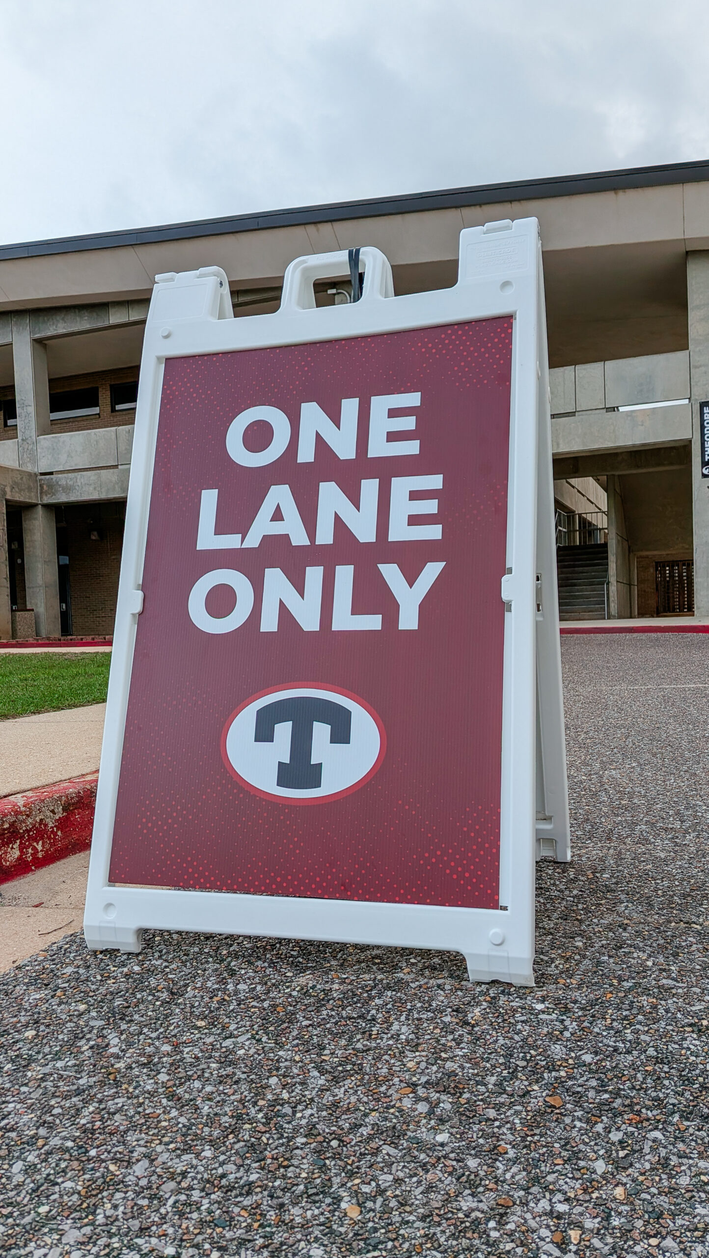 A-frame sign with Theodore High School branding placed in parking lot