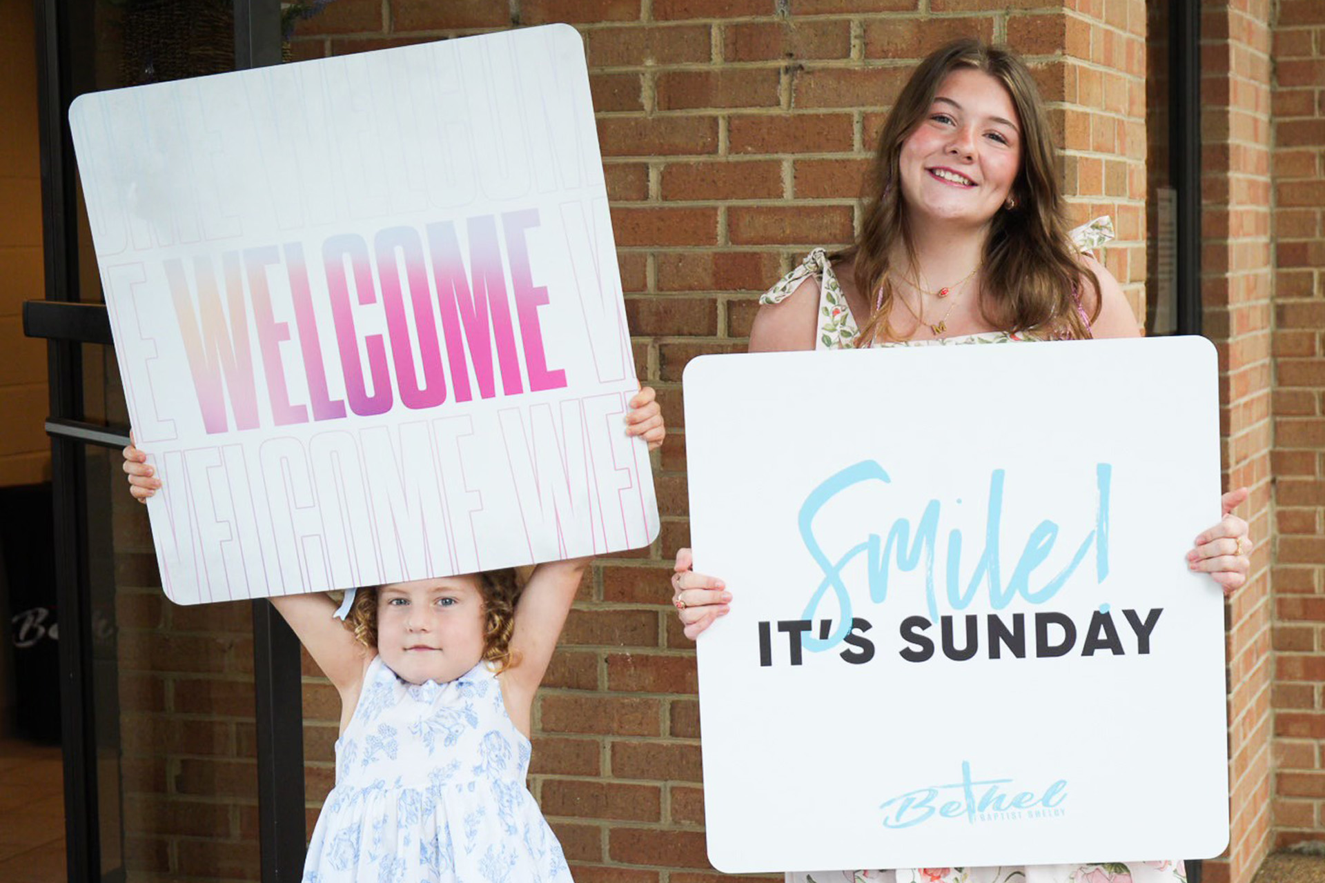 Custom handheld welcome signs used by church welcome team volunteers to greet guests.